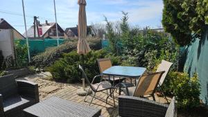 a patio with a table and chairs and an umbrella at Sunlight Apartmanház in Velence