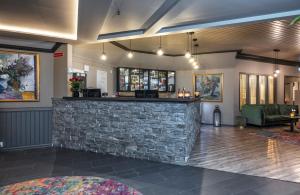 a bar in a room with a stone wall at Thon Hotel Baronen in Ålesund