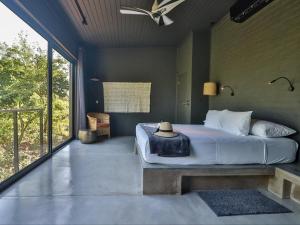 a bedroom with a bed and a large window at Akasha by Kruger Nights in Marloth Park +42 photos