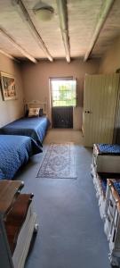 a large room with two beds and a door at Ouma Bettie Guesthouse in Piketberg