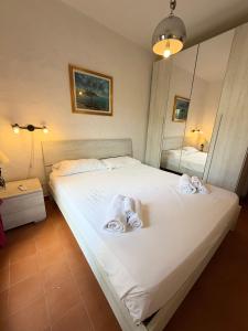 a bedroom with a bed with towels on it at Bilocali Ibiscus - 700mt dalla spiaggia in Porto Ottiolu