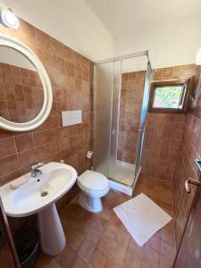a bathroom with a toilet and a sink and a shower at Bilocali Ibiscus - 700mt dalla spiaggia in Porto Ottiolu +21 photos