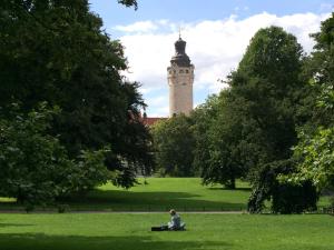 een persoon in het gras voor een toren bij LE-Citywohnung-I in Leipzig