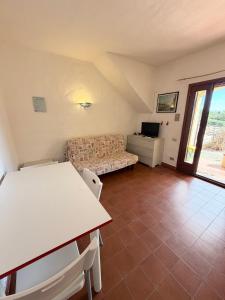 a living room with a couch and a table at Bilocali Ibiscus - 700mt dalla spiaggia in Porto Ottiolu