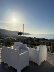 a balcony with white furniture and a view of the ocean at Acrita Superior in Mandaradoni