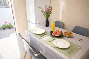 a table with plates of food and a vase with flowers at Cascais Garden House 101 in Cascais