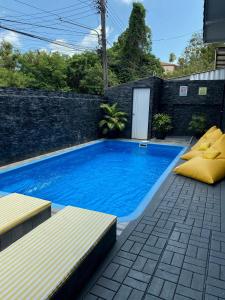 a swimming pool in a backyard with two yellow pillows at L.C. Apartments in Lamai