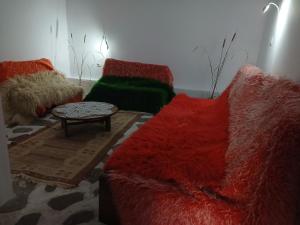a living room with red and green couches and a table at Edward Lear - Heritage Guest House in Berat +38 photos