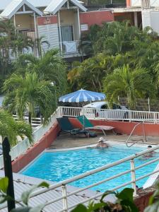 a person in the swimming pool at a resort at Studio MESANGE TARTANE in La Trinité