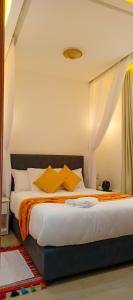 a bedroom with a large bed with yellow pillows at Bonds Hotel in Nairobi