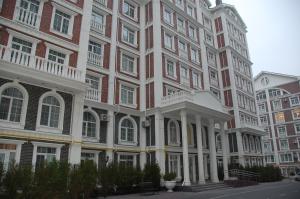 a large brick building with white columns and windows at Green Apple Hostel in Kyiv