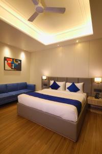 a bedroom with a large bed and a blue couch at BB Grand in Sunām +10 photos