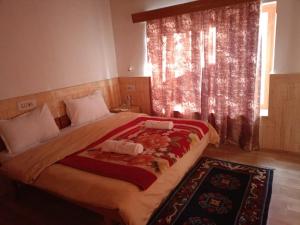 a bedroom with a large bed and a window at AO Guest House in Nubra +4 photos