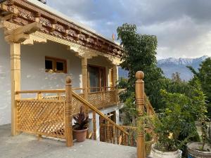 a house with a balcony with a view of the mountains at AO Guest House in Nubra