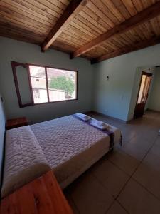 a large bed in a room with a large window at Dúplex céntrico LAS SOFIAS - PURMAMARCA in Purmamarca