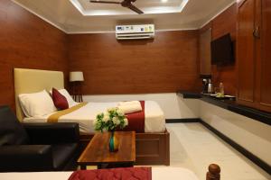 a hotel room with a bed and a couch at SVS Grand in Dindigul