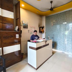 a man standing at a counter in a room at SIYA International Lodging And Boarding in Bhiwandi