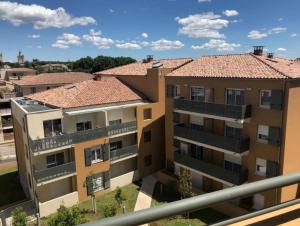 an apartment building with two balconies on the side at Appart One Uzès in Uzès