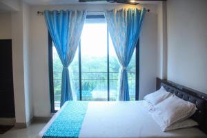 a bedroom with a bed and a large window at SIYA International Lodging And Boarding in Bhiwandi