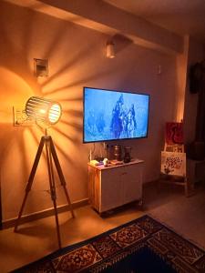 a room with a flat screen tv and a fan at J kutir in Siliguri