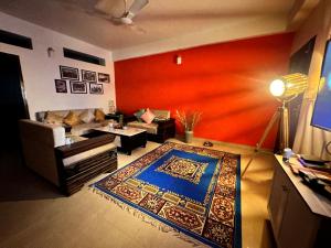 a living room with a couch and a rug at J kutir in Siliguri +1 photo