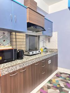 a kitchen with wooden cabinets and a microwave at J kutir in Siliguri