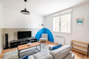 a living room with a couch and a table at L'Echappée Choletaise, simple et familiale! in Cholet