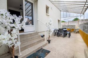 a patio with a table and chairs and trees at L'Echappée Choletaise, simple et familiale! in Cholet