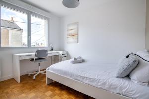 a bedroom with a bed and a desk and a chair at L'Echappée Choletaise, simple et familiale! in Cholet