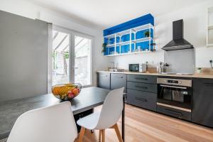 a kitchen with blue cabinets and a table and chairs at L'Echappée Choletaise, simple et familiale! in Cholet