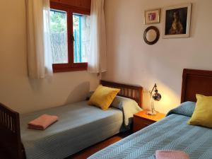a bedroom with two beds and a window at La Campanera in Las Navas del Marqués