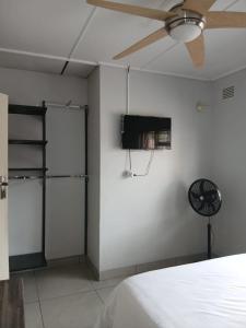 a bedroom with a bed and a ceiling fan at Abebe Guest House in George