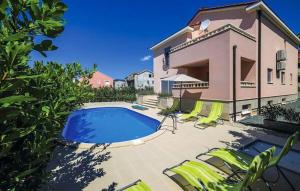 a house with a swimming pool and some lawn chairs at Vila Giulietta in Kaštela