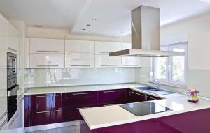 a kitchen with purple and white cabinets and a sink at Vila Giulietta in Kaštela