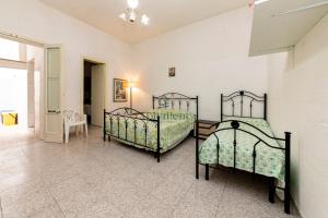 two twin beds in a room with a hallway at La Dimora del Centro - San Foca in San Foca
