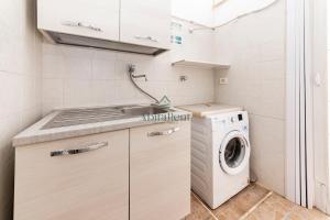 a small kitchen with a washing machine and a sink at La Dimora del Centro - San Foca in San Foca