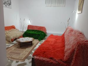 a living room with red and green couches and a table at Edward Lear - Heritage Guest House in Berat