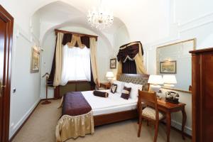 a bedroom with a bed and a table and a chair at Hotel Leopold I in Novi Sad +111 photos