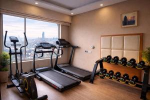 a gym with two tread machines and a window at Days Hotel, Baridhara in Dhaka