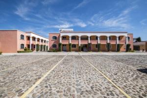 a large pink building on a stone road at OYO Hotel La Glorieta, Huichapan in Huichapan