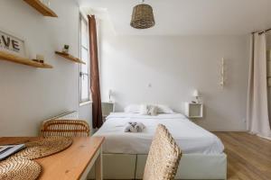 a bedroom with a white bed and a wooden table at Nid Amour Cabane et Spa Privatif in Rouen