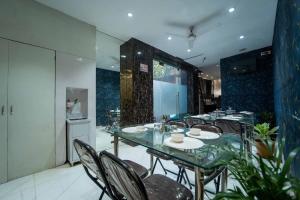 a dining room with a glass table and chairs at Glitz Rexton Inn - Near IIT Powai in Mumbai