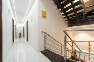 a hallway with white walls and a metal railing at Glitz Rexton Inn - Near IIT Powai in Mumbai