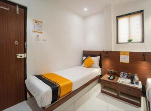 a small bedroom with a bed and a table at Glitz Rexton Inn - Near IIT Powai in Mumbai