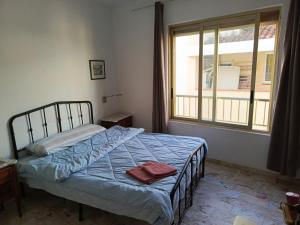 a bedroom with a bed and a large window at Habitacion en piso compartido No alojamiento turistico in Benidorm