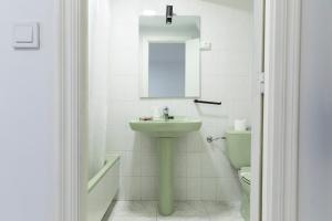 a bathroom with a sink and a toilet and a mirror at Amarantos in Suances