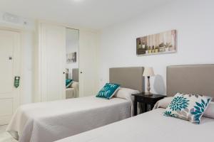 two beds in a room with white walls at Amarantos in Suances