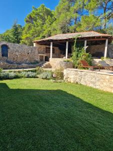 a house with a grass yard and a building at Vila Lovrečina in Postira