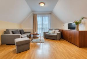 a living room with two couches and a flat screen tv at Resort Levočská Dolina in Levoča