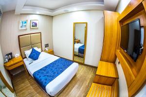 a hotel room with a bed and a television at Days Hotel, Baridhara in Dhaka +35 photos